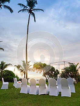 Beautiful sunset on the ocean. Chairs standing in row at wedding ceremony