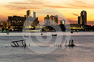 Beautiful Sunset Orange sky and boat at Pattaya Sea, Backdrop Building of pattaya city in Thailand