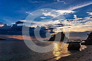 Sunset over a beach by the coral garden on San Antonio island, Puerto Galera, Oriental Mindoro region in the Philippines photo