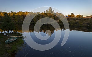 Colorful autumn landscape with lake and boat on background at sunset