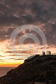 Beautiful sunset over the cliff of The Temple of Poseidon at Cape Sounion, over the Aegean Sea Greece