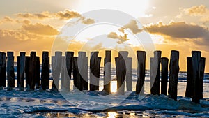 Beautiful Sunset over groynes in Zeeland photo