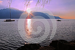 Beautiful sunset over Lake Geneva with sun rays peeking from the
