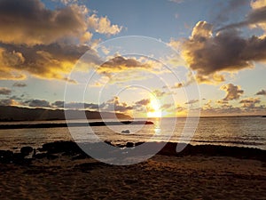 Beautiful Sunset over the ocean along rocky shore