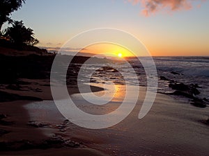 Beautiful Sunset over the ocean and beach with waves moving to shore