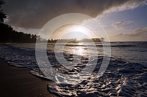 Beautiful Sunset over the ocean with waves moving across the san