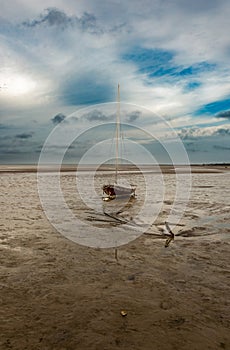 Beautiful sunset over an old fishing boat on a Brewster flats beach wit low tide