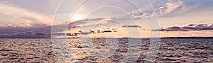 Beautiful sunset over sea with reflection in water, majestic clouds in the sky. BANNER, LONG FORMAT