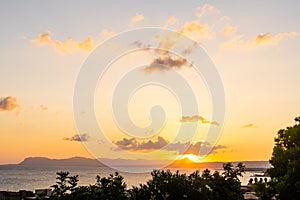 Beautiful sunset over the sea with a view at palms on the beach