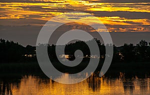 Beautiful sunset over the swamp in Louisiana, the reflection of clouds in the water, USA