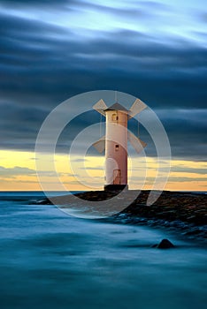 Beautiful sunset over a windmill-shaped lighthouse. Swinoujscie, Poland.