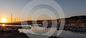 Beautiful sunset panoramic view of a port at sunset with multiple sailboats. Arenys de Mar village in El Maresme coast, Barcelona photo