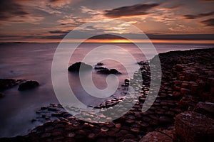 Beautiful sunset picture about sea horizon, and unique volcanic rock formations at Giants Causeway, Norht Ireland