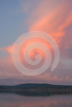 Beautiful sunset with red clouds on a small European lake, reflected on the surface of the water. Fishing and recreation