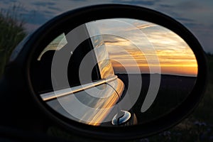 A beautiful sunset is reflected in a rear-view mirror photo