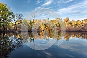 Beautiful sunset on the river in forest with sky reflection