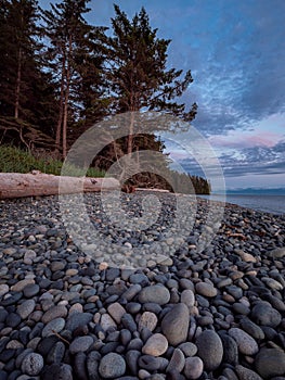 Beautiful sunset on round rocky beach along French Beach on Vancouver Island, British Columbia, Canada