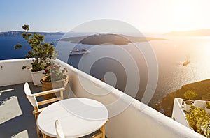 Beautiful sunset at Santorini island, Greece. Two chairs on terrace with sea view
