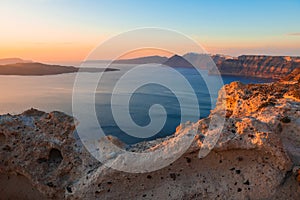 Beautiful sunset at Santorini island, Greece. Volcanic rocks in the foreground