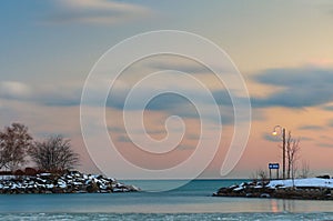 Beautiful sunset scene of colorful orange sky over snowy beach in Scarborough, Ontario photo