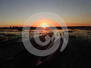 Beautiful sunset scenery with boats at the coast in Okavango Delta, Botswana