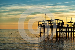 beautiful sunset on the sea. pier with umbrellas and sunbeds for vacationers