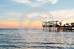 beautiful sunset on the sea. pier with umbrellas and sunbeds for vacationers