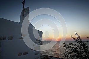 Beautiful sunset seen from the church of Agios Konstantinou, a traditional Cycladic church with blue dome in the town of Paroikia