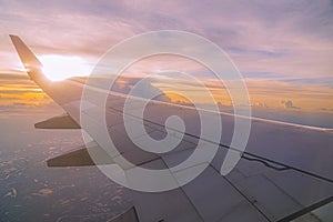 Beautiful sunset, sky on the top view, airplane flying view from inside window and cloud, sun down background.