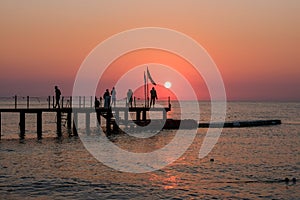 Beautiful sunset sunrise beach with pink sky and pier. Travel, relax and meditation concept