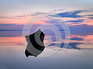 Beautiful sunset/sunrise over water and silhouette fishing boat