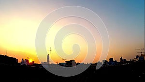 Beautiful sunset and super wide top view in modern city over rooftops. Vivid sun fades and changes over skyline. Movement of