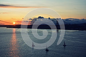 Beautiful sunset. Tejo river. 25th April bridge. Lisbon. Portugal. Almada. Clouds. Yacht. Boat. Sun. Colourfully. Light. Sunlight.