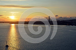 Beautiful sunset. Tejo river. 25th April bridge. Lisbon. Portugal. Almada. Clouds. Yacht. Boat. Sun. Colourfully. Sunlight. Light.