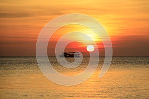 Beautiful sunset and tourist boat floating over peaceful sea