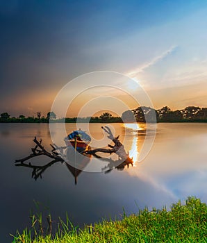 Beautiful sunset and traditional Beautiful little fishing boat with fantastic golden sky and nature photo