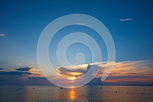 Beautiful sunset in the tropical sea. Silhouettes of ships, bathers and fishermen