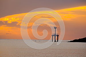 Beautiful sunset view on the beach. Colorful sea beach sunset with golden light reflected on the water surface and soft waves.