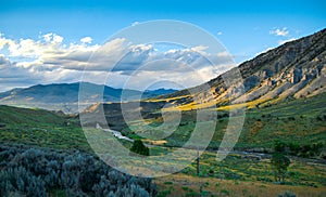 Beautiful sunset view of Yellowstone National Park, southern part. Mountain hills filled with green grass and trees in the summer photo