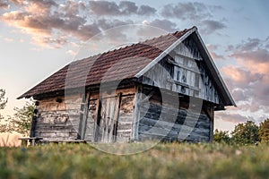 Beautiful sunset in the vineyard of the village with a wooden house