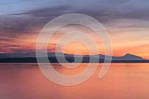 Beautiful sunset where the ocean and mountains meet at the horizon