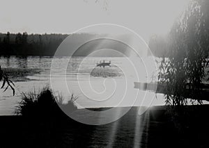 Beautiful sunshine on a lake landscape photo fishing boat black and white film photography Pentax have negative for print