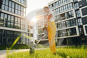 Beautiful sunshine. Man cut the grass with lawn mover outdoors in the yard