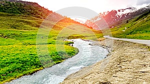 Beautiful sunshine scenery landscape of the mountains In the summer With green fields and streams water in nature background,