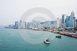 Beautiful super wide-angle summer aerial view of Hong Kong island skyline, Victoria Bay harbor, with skyscrapers, blue sky