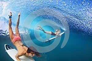 Beautiful surfer girl diving under water with surf board