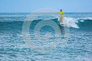 Beautiful surfer girl rides a longboard