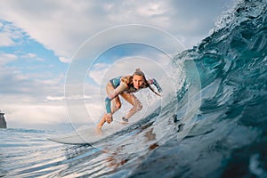 Beautiful surfer girl on surfboard. Woman in ocean during surfing. Surfer and barrel wave