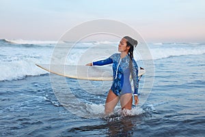 Beautiful Surfer Girl. Surfing Woman With Surfboard Standing In Ocean. Brunette In Blue Wetsuit Waiting Wave.