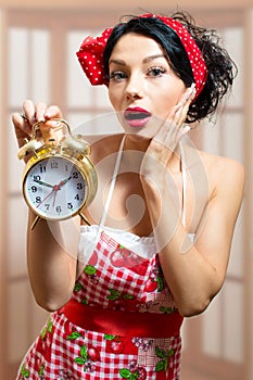 Beautiful surprised pinup girl holding alarm clock